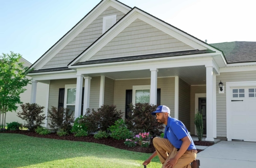 Person working with a sprinkler in a front yard